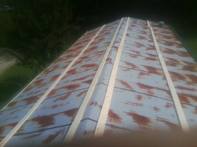 Rusted metal roof panels with new wood purlins before replacement — Storm Damage Roof Repair in De Leon Springs by Roofing Brothers